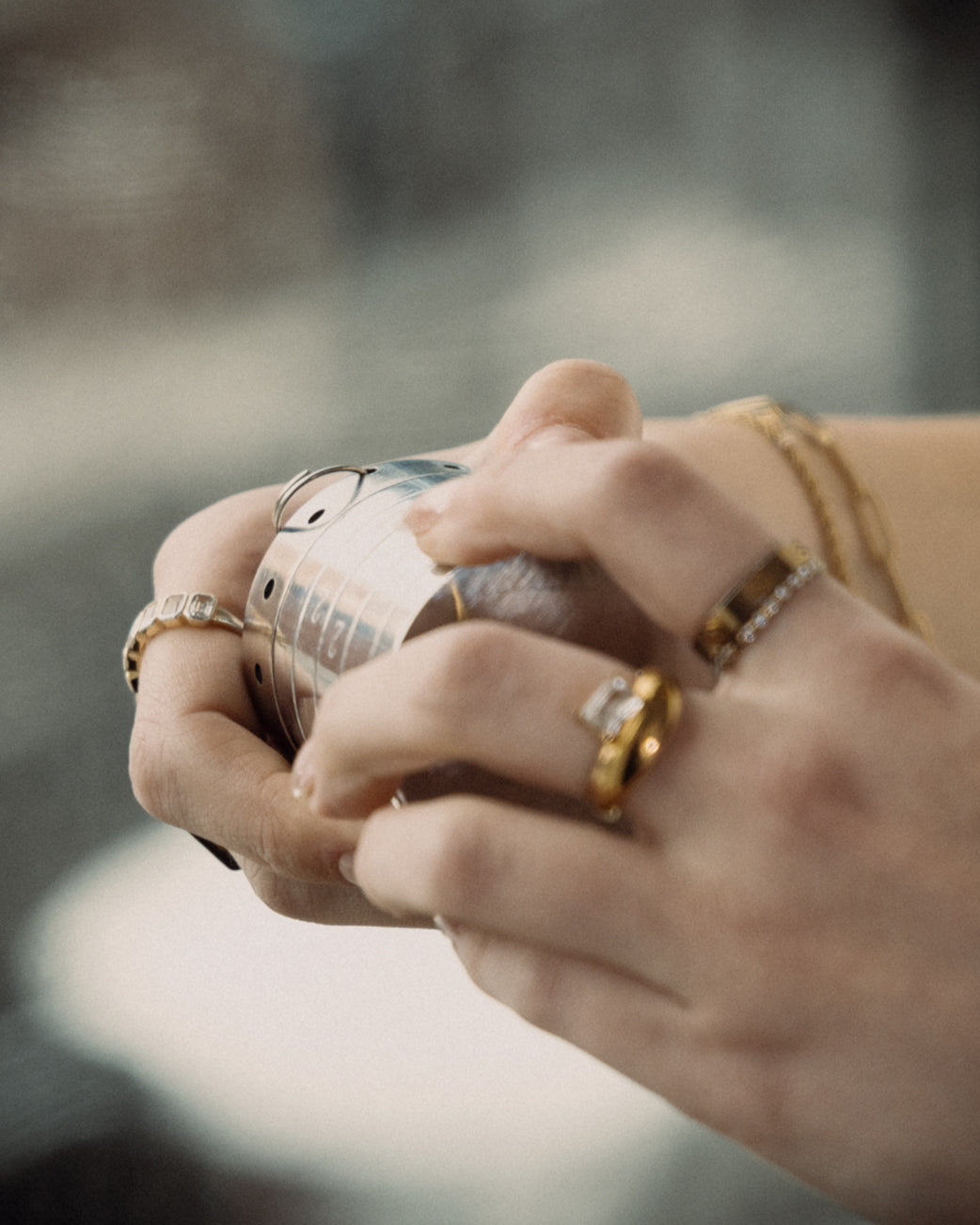 Close-up of elegantly adorned hands adjusting the Rock Lock jewelry security container. Gold rings, diamond accents, and delicate bracelets highlight the perfect balance of luxury and protection for valuable accessories.