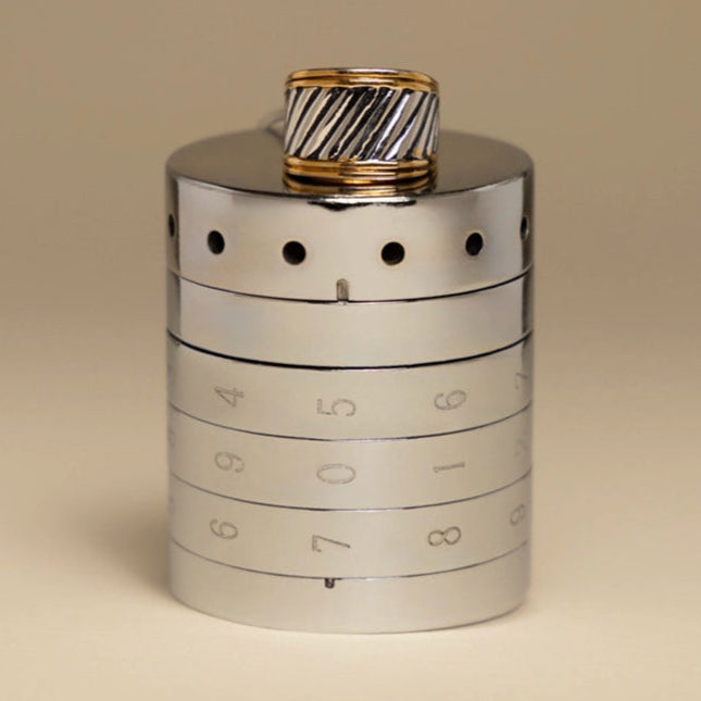 A sleek silver RockLock jewelry lockbox with a stylish men’s gold and silver ring placed on top. Designed for security and elegance, RockLock keeps valuable rings safe and trackable at home or on the go.
