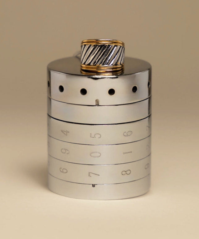 A sleek silver RockLock jewelry lockbox with a stylish men’s gold and silver ring placed on top. Designed for security and elegance, RockLock keeps valuable rings safe and trackable at home or on the go.
